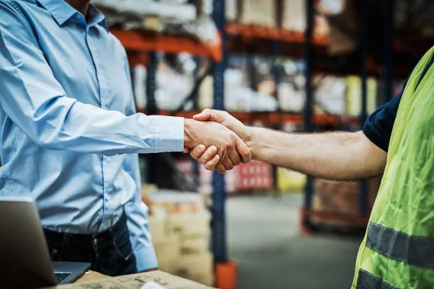 Two people shaking hands in a warehouse